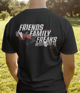 Person wearing a black t-shirt with text and graphics on the back, standing outdoors.